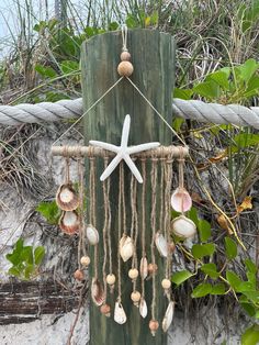 a starfish and seashells hanging from a wooden post