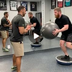 two men are doing exercises on an exercise ball while another man watches from the sidelines