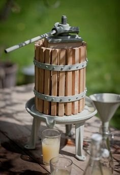 a wooden barrel sitting on top of a table next to a glass filled with liquid