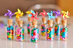 small glass bottles filled with colorful candies and paper birds