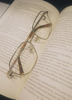 an open book with glasses sitting on top of it