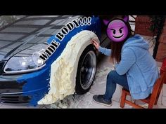 a person sitting on a chair next to a car with a face painted on it