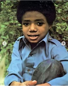 an image of a young boy that is wearing a blue shirt and holding something in his hand