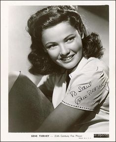 an old black and white photo of a woman smiling