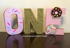 the letter n is decorated with donuts and sprinkles on it's sides