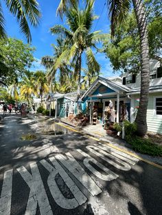 a street lined with palm trees and shops