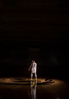 a basketball player is standing in the dark