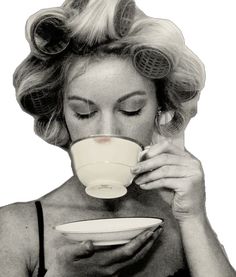 a black and white photo of a woman drinking from a coffee cup