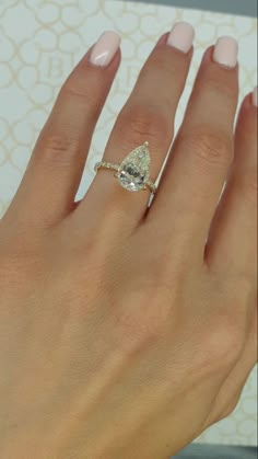 a woman's hand with a diamond ring on it