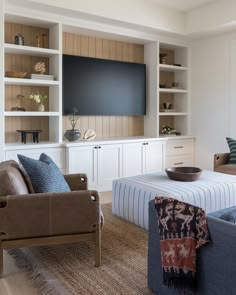 a living room filled with furniture and a flat screen tv mounted to the side of a wall