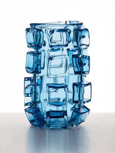 a blue glass vase sitting on top of a table