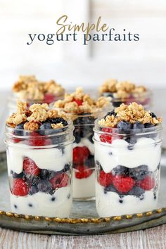 yogurt parfaits with berries and granola in jars on a tray