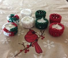 several crocheted candles are sitting on a table with snowflakes around them