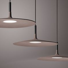 three circular lights hanging from the ceiling in a room with gray walls and flooring