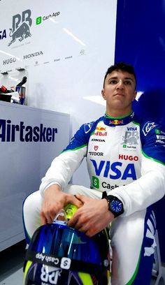 a man sitting on top of a motorcycle next to a blue and white wall with an airtasker logo