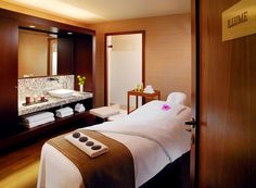 a spa room with a large mirror and white towels on the back of the bed