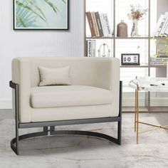 a living room with a chair, table and bookshelf in front of the window