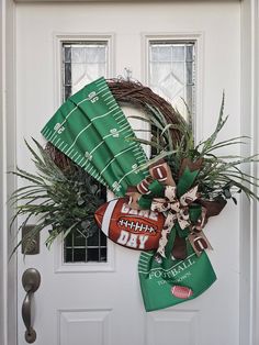 a football wreath is hung on the front door with green and brown decorations, as well as an american football fan