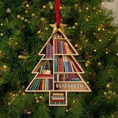 a wooden christmas tree ornament with books on it