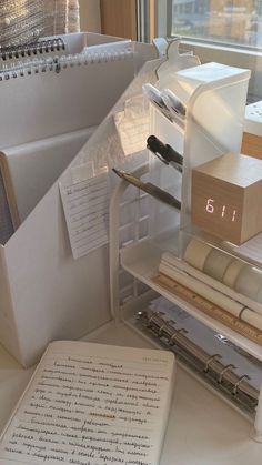 an open book sitting on top of a white table next to a pile of books