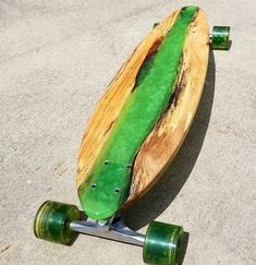 a skateboard with green wheels laying on the ground