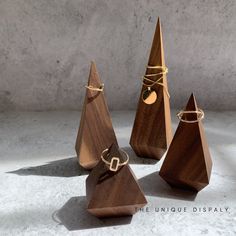 three wooden pyramids with rings tied to them