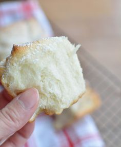 a hand holding a half eaten piece of bread