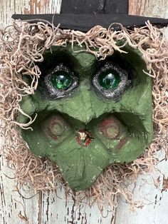 a close up of a mask with green eyes