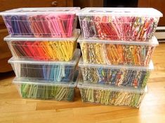 several plastic containers filled with lots of different colored paper clips on top of a wooden floor