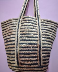 a black and white striped bag hanging on a purple wall next to a pair of scissors