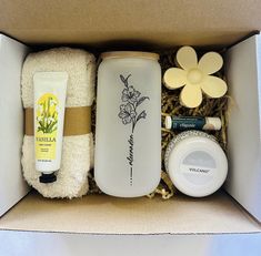 an open box containing various items including hand creams, body lotion and flowers