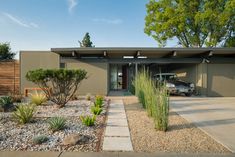 a car is parked in front of a house with gravel and rocks on the ground