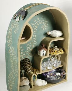 a shelf that has various items in it and is decorated with gold chains on the top