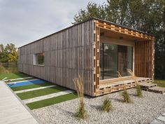 a small wooden cabin sitting on top of a grass covered field next to a swimming pool