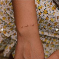 a woman's arm with a small tattoo on the wrist that says love in cursive writing