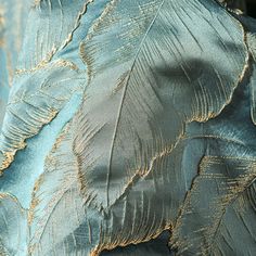 the back of a blue dress with gold feathers on it