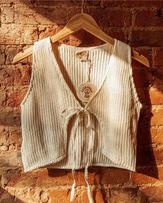 Sweet boho style knit vest, lovingly crafted from 100% GOTS certified organic unbleached cotton. This cropped vest from Gardenbelle Shop embraces a laid-back beachy vibe, offering a perfect lightweight layer without being too hot. Designed for the conscious fashionista, it beautifully embodies our commitment to sustainability and ethical fashion. Elevate your wardrobe with this versatile piece that's both stylish and comfortable, perfect for any casual outing or a sunlit stroll. Add a touch of o Beige Cotton V-neck Knit Top, Bohemian Knitted V-neck Top, Bohemian V-neck Knitted Top, Summer Cotton V-neck Vest, Bohemian Cotton Crochet V-neck Top, Cozy Cotton Tops For Beach, Knitted Cotton Tops For Layering, Sleeveless Cotton Crochet Top For Fall, Cozy Cotton Beach Top