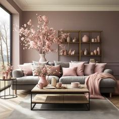 a living room filled with lots of furniture and pink flowers in vases on the wall