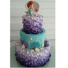 a three tiered cake decorated with purple and blue icing