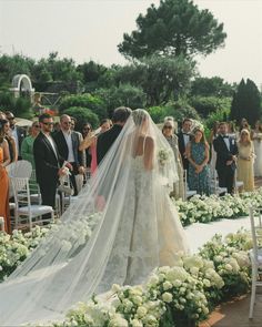 a bride and groom walking down the aisle at their wedding ceremony in front of an audience