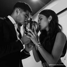 a man and woman are looking at an award