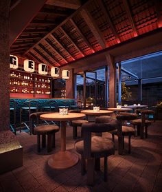 a dimly lit restaurant with tables and stools in front of large windows at night