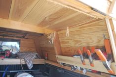 the inside of a truck with tools hanging from it's ceiling and bed in the back