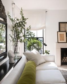 a living room filled with furniture and a large mirror on the wall next to a fire place