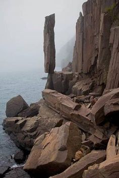 some rocks and water on a foggy day