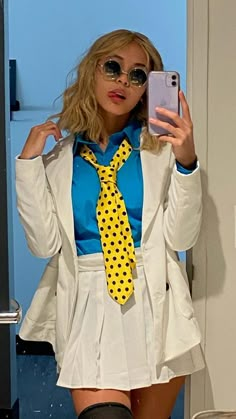 a woman is taking a selfie in the mirror wearing a white suit and yellow polka dot tie