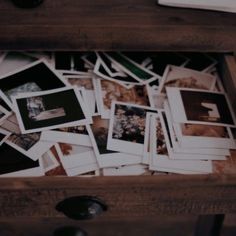 an open drawer with many photos on it