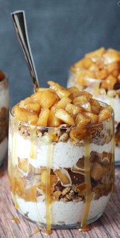 two desserts in glass bowls with spoons on the top one is filled with fruit and has caramel sauce drizzled over it