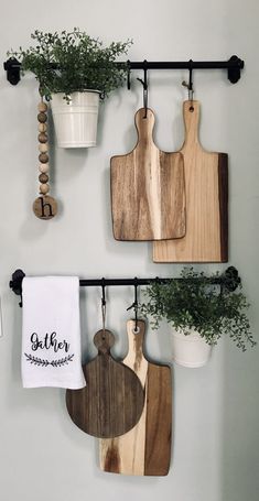 three wooden cutting boards hanging on a wall