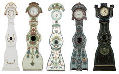 four different clocks are standing side by side in the same row, each with unique designs on them